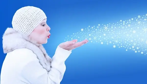 girl in winter blowing snow