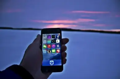 hand holding phone at snowy sunset