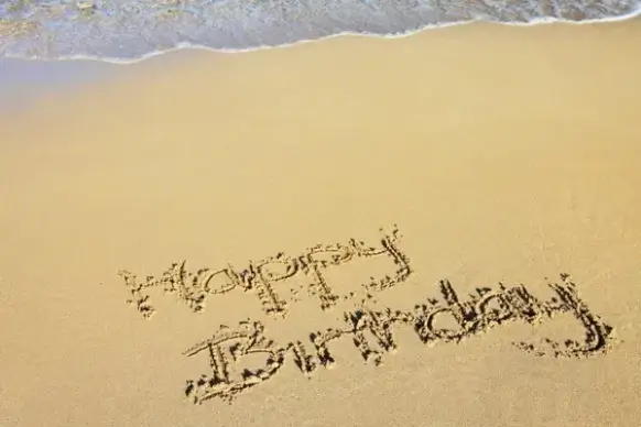 happy birthday in sand