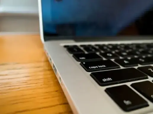 laptop on wooden desk with keyboard