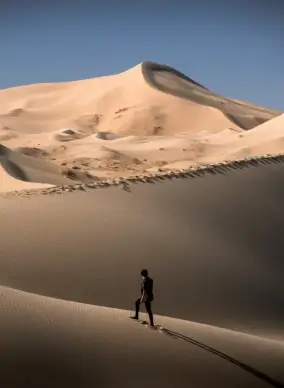 mexico scenery picture man walking on sand dune