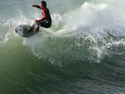 surfer carves to the wavecrest