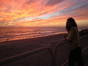 woman at the beach with sunset clouds