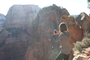 woman taking cell phone picture of mountains