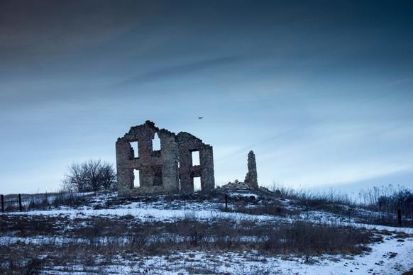 abandoned building in the winter in wisconsin with drone in sky