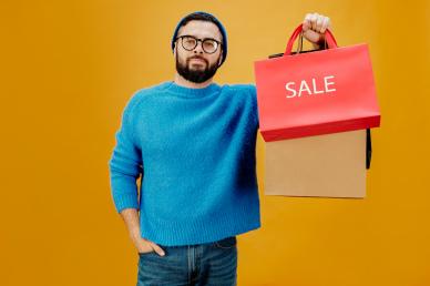 black friday sale banner man holding shopping bags