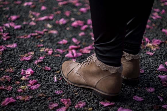 rumpled flowers surrounding feet with boots