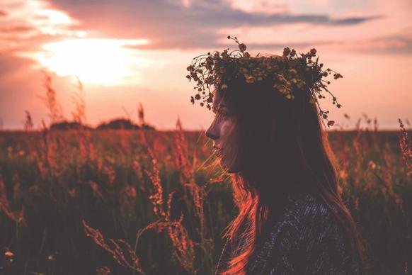 young girl with flowers wreath at sunset