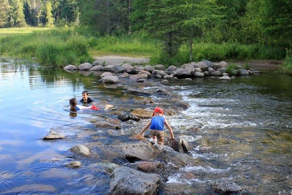 children playing in the rapids at lake itasca state park minnesota