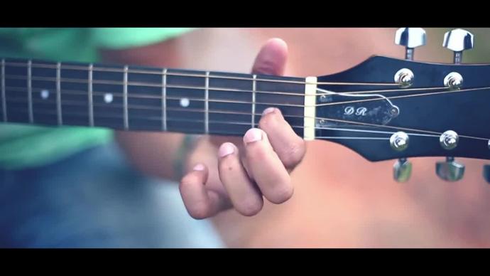 closeup of man playing acoustic guitar