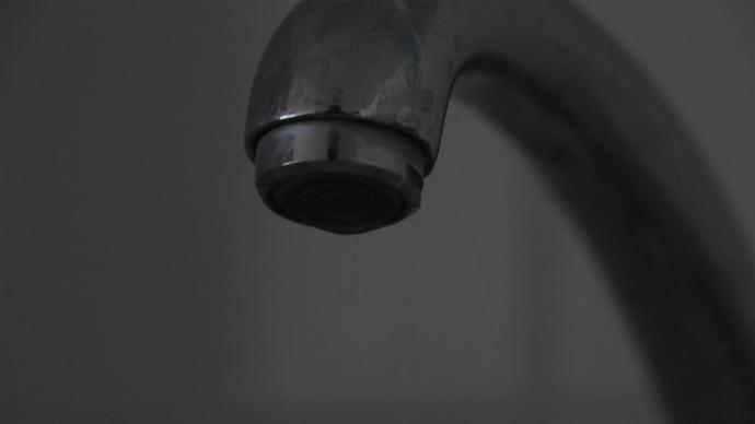 closeup of water drops falling from tap