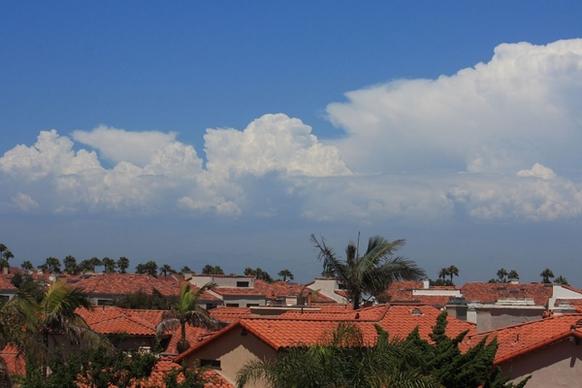 cloudscape over red tile roofs