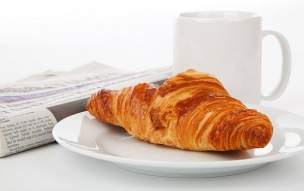 croissant newspaper and tea