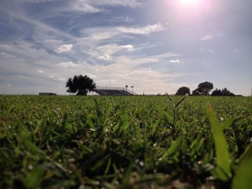 grass field with bleachers in distance