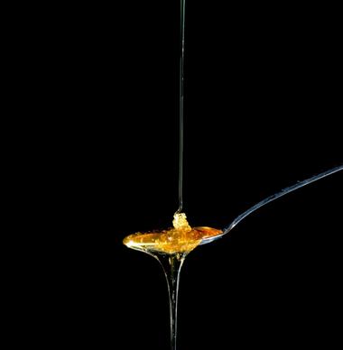 closeup of honey droplets on spoon