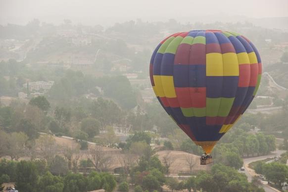 hot air balloon floating above countryside