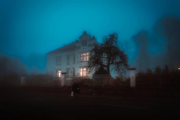 man in front of house covered by fog