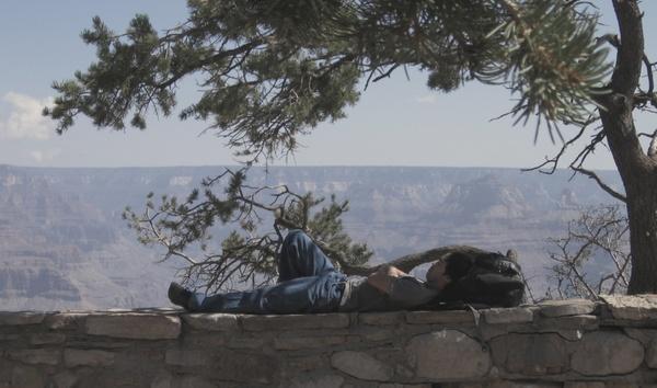 man lying on wall ledge