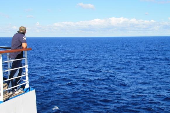 man on deck of cruise ship looking at ocean