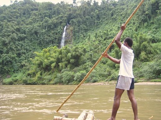 man on raft in a river through the jungle