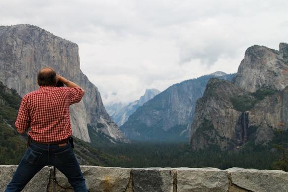 man taking photos of mountains