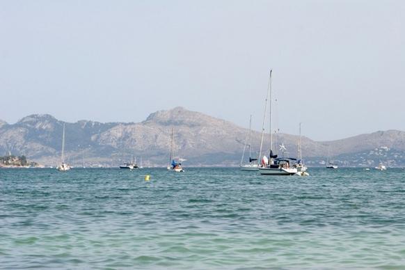 sailboats idling in mediterranean bay