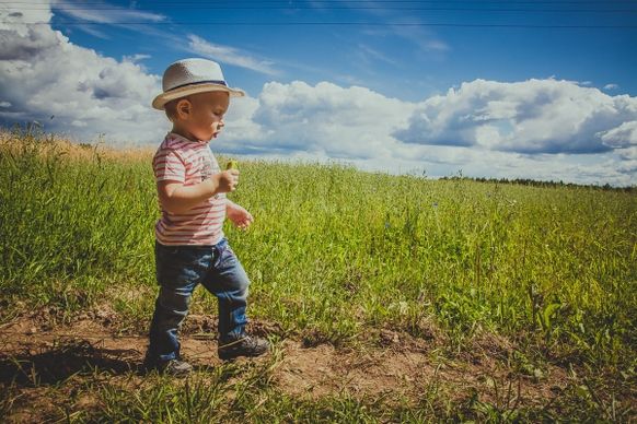 tiny boy walking on meadow
