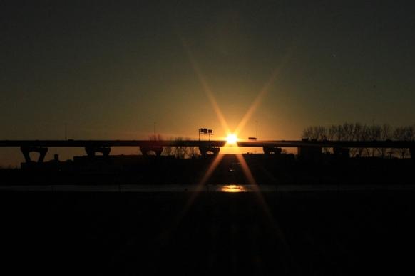 sun behind highway bridge in milwaukee wisconsin