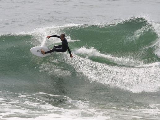 surfer carves to the wavecrest