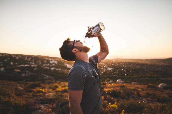 thirsty man drinking bottled water