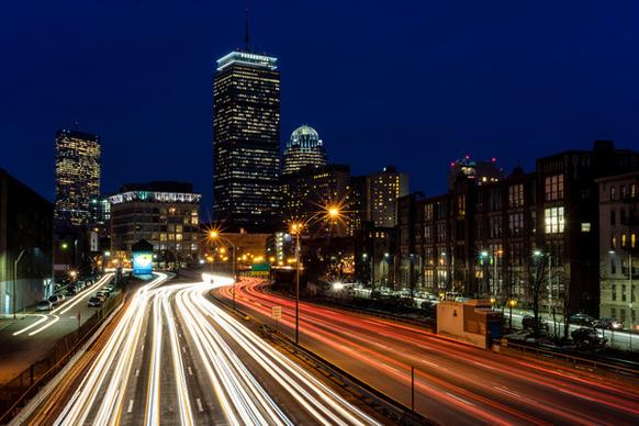 traffic streaming through downtown boston just after sunset